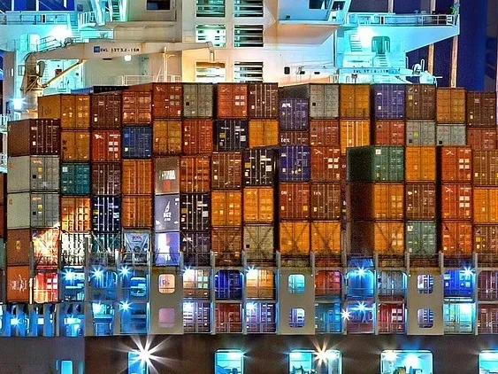 Stacked shipping containers on a cargo ship at night